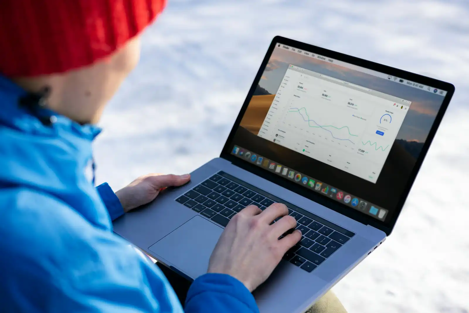 Person analyzing digital marketing campaign metrics on laptop computer outdoors