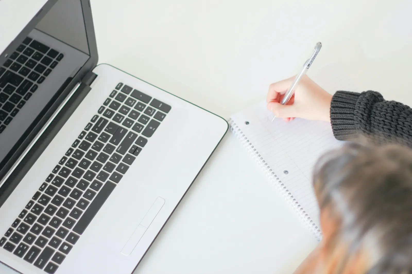 Person writing copywriting strategy notes at desk for lead generation planning